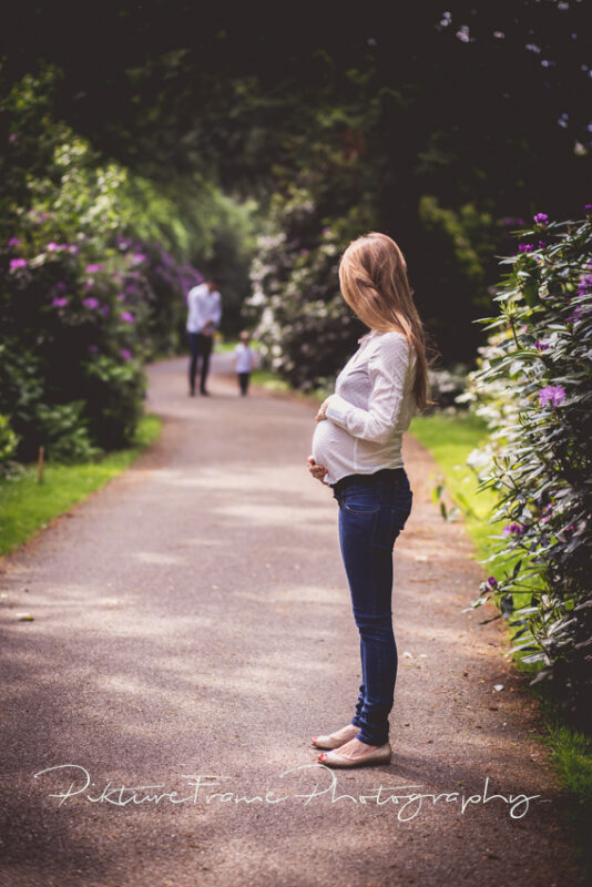 Zwangerschapsreportage in buitenlucht tussen rhododendron